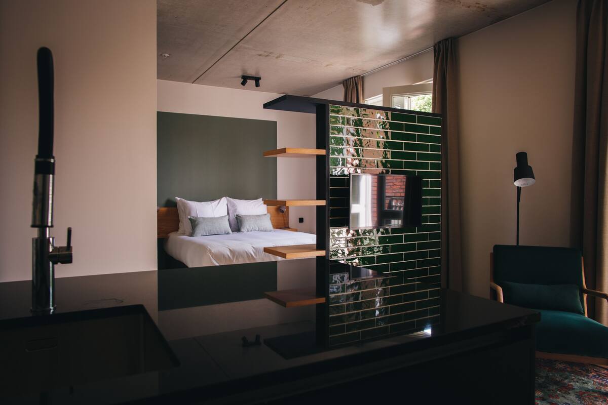 Una habitación de hotel moderna con una cama, un escritorio y una silla.