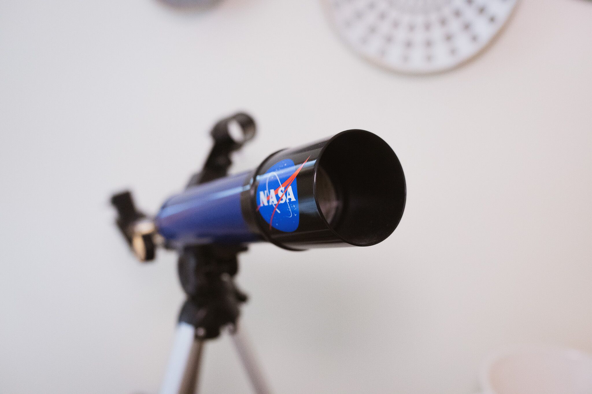 A telescope with a NASA logo on its body, mounted on a tripod.