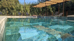 A clear swimming pool with a tiled deck, surrounded by a metal fence and shaded by a canopy. - Avignon - Mas de la Roule - 18 people - Swimming pool - Park 2 ha (Avignon)