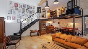 A loft-style living area with a staircase, a sofa, a coffee table, and a dining area. - Avignon - Mas de la Roule - 18 people - Swimming pool - Park 2 ha (Avignon)