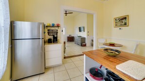 Una cucina moderna con frigorifero in acciaio inossidabile, angolo caffè e tavolo da pranzo in legno.