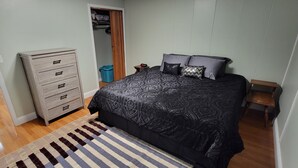 Une chambre à coucher comprenant un lit, une commode, un placard et une petite table.