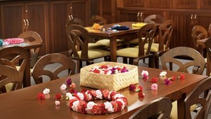 Un coin repas avec une table en bois, des chaises et un panier en osier contenant des fleurs.