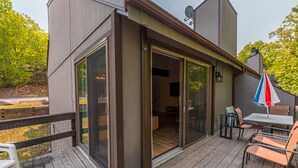 A wooden deck with a sliding glass door leading to a room with a table and chairs. - Modern and Brand New, Pool, Camelback Ski Area, 2 showers (Tannersville)
