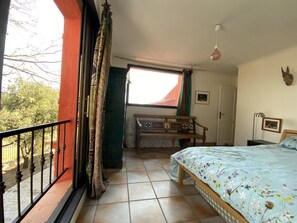 Enjoy a restful stay in this cozy room with a large bed and scenic view, a wooden bench, and a small table.