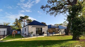 A modern two-story house with a fenced backyard, a patio with outdoor furniture, and a well-maintained lawn. - Villa Armor Azur - ERQUY (ERQUY)