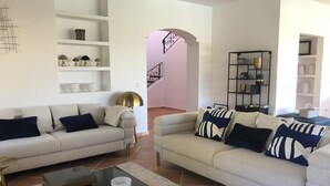 A modern living room with two sofas, a coffee table, and a bookshelf. - VILLA WITH POOL 5 MINUTES FROM THE BEACH (TORREGUADIARO)