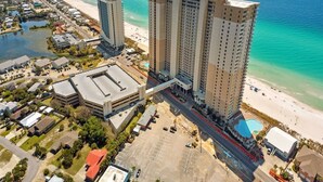 Ein Hochhotel mit mehreren Etagen, Blick auf den Strand und einem Parkplatz.