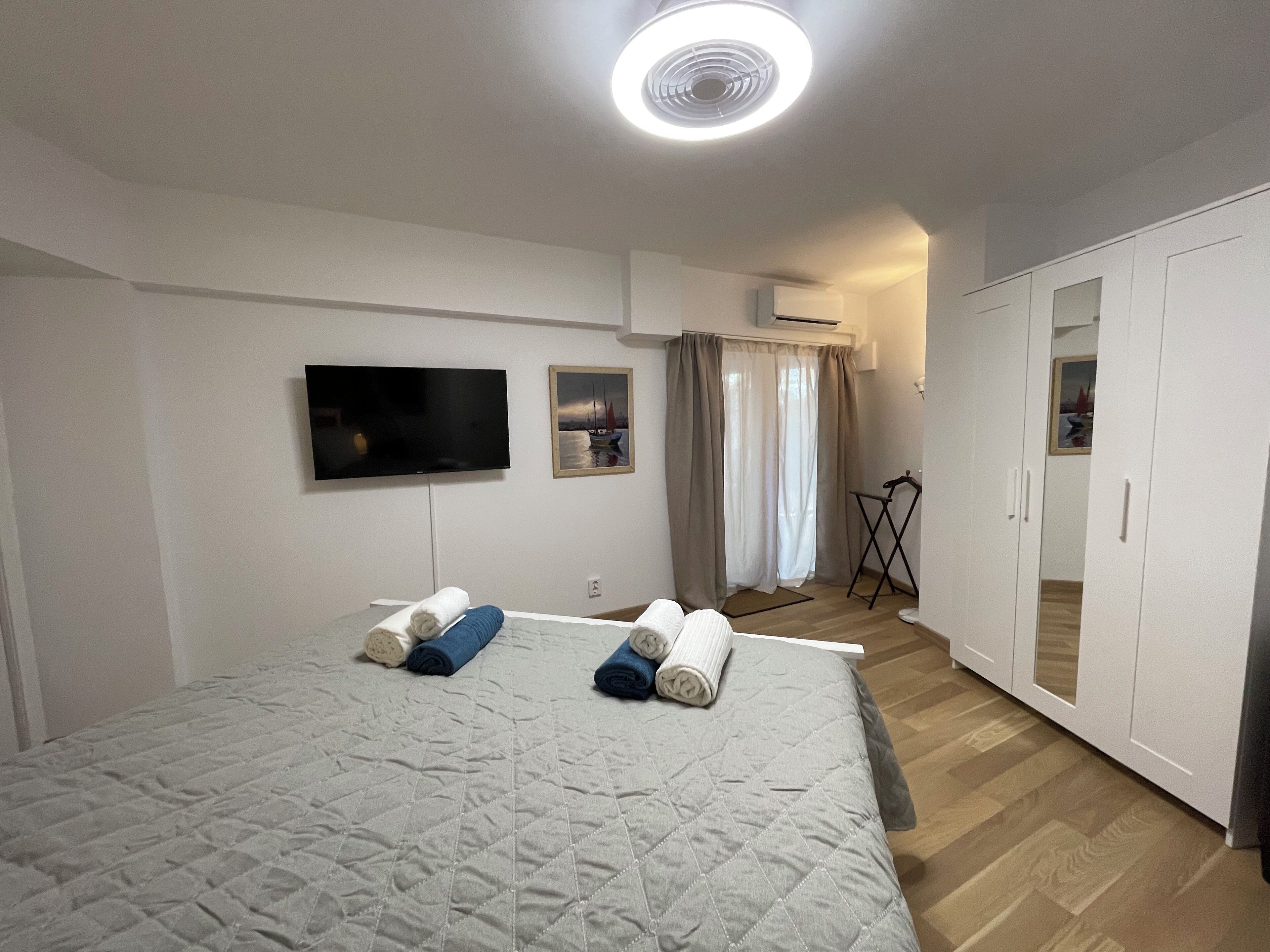 Une chambre à coucher avec un lit, une télévision, un tableau et une armoire.