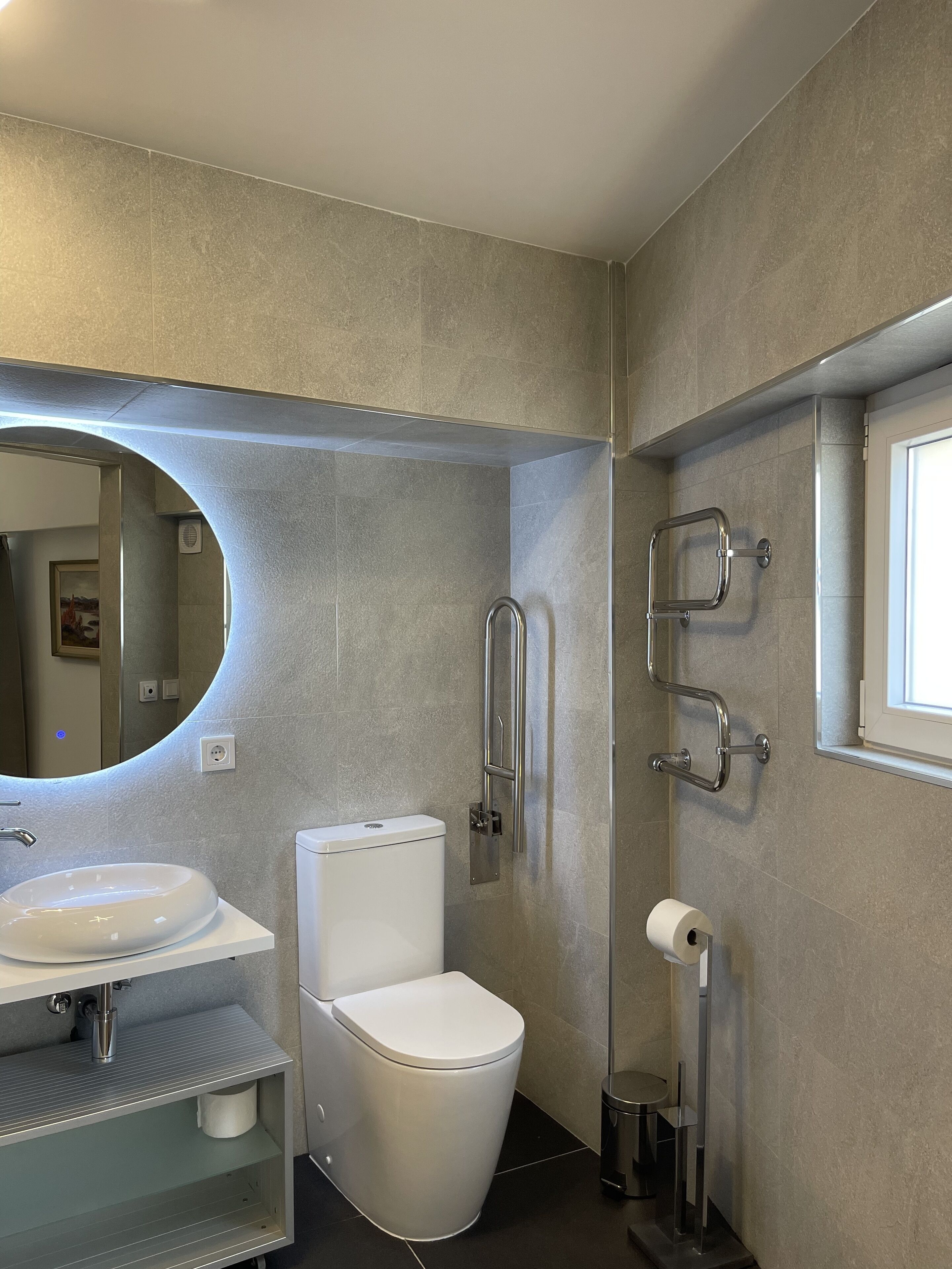 Ein modernes Badezimmer mit Toilette, Waschbecken und Duschbereich.