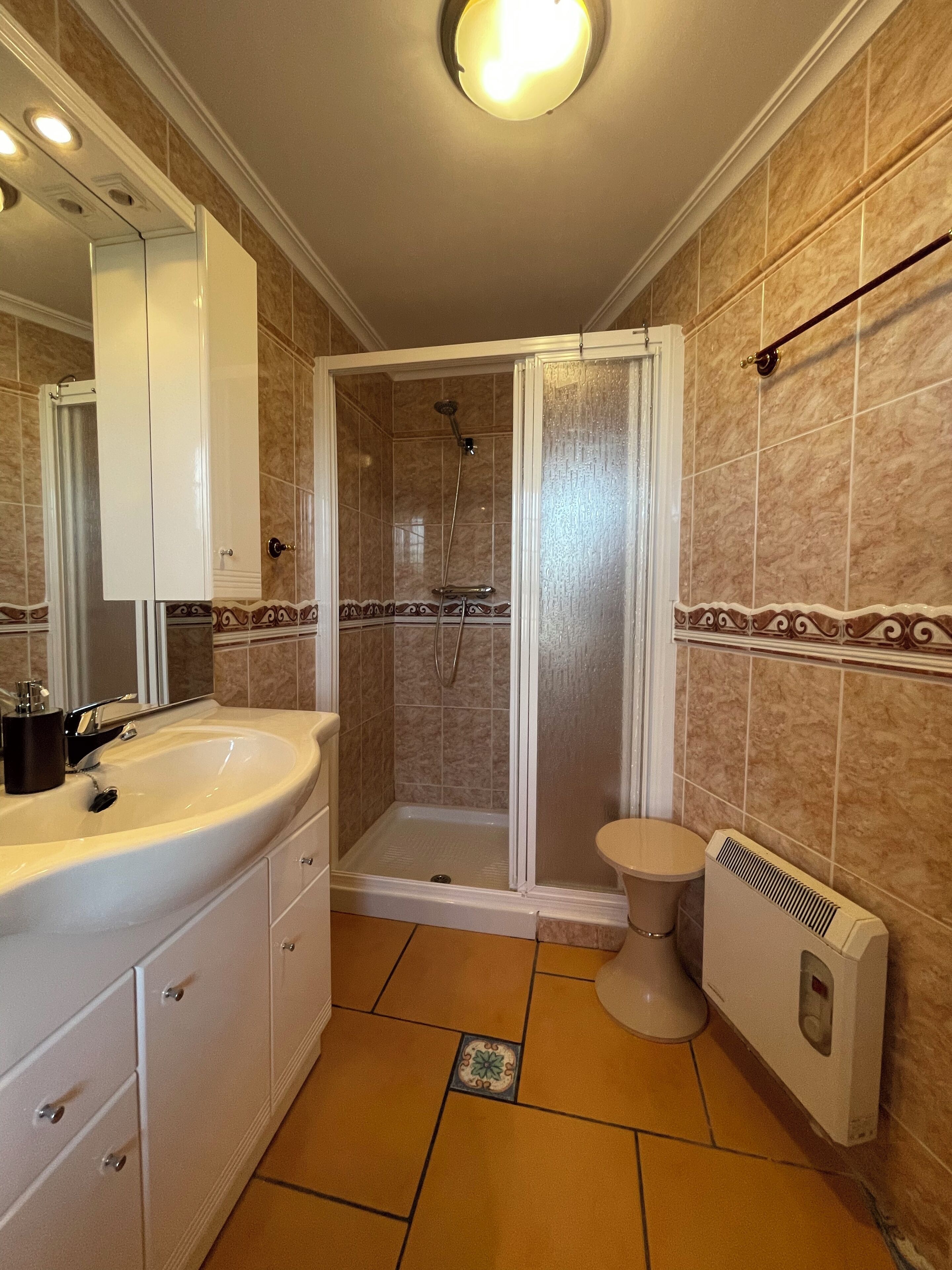 Ein Badezimmer mit Dusche, Toilette und Waschbecken.