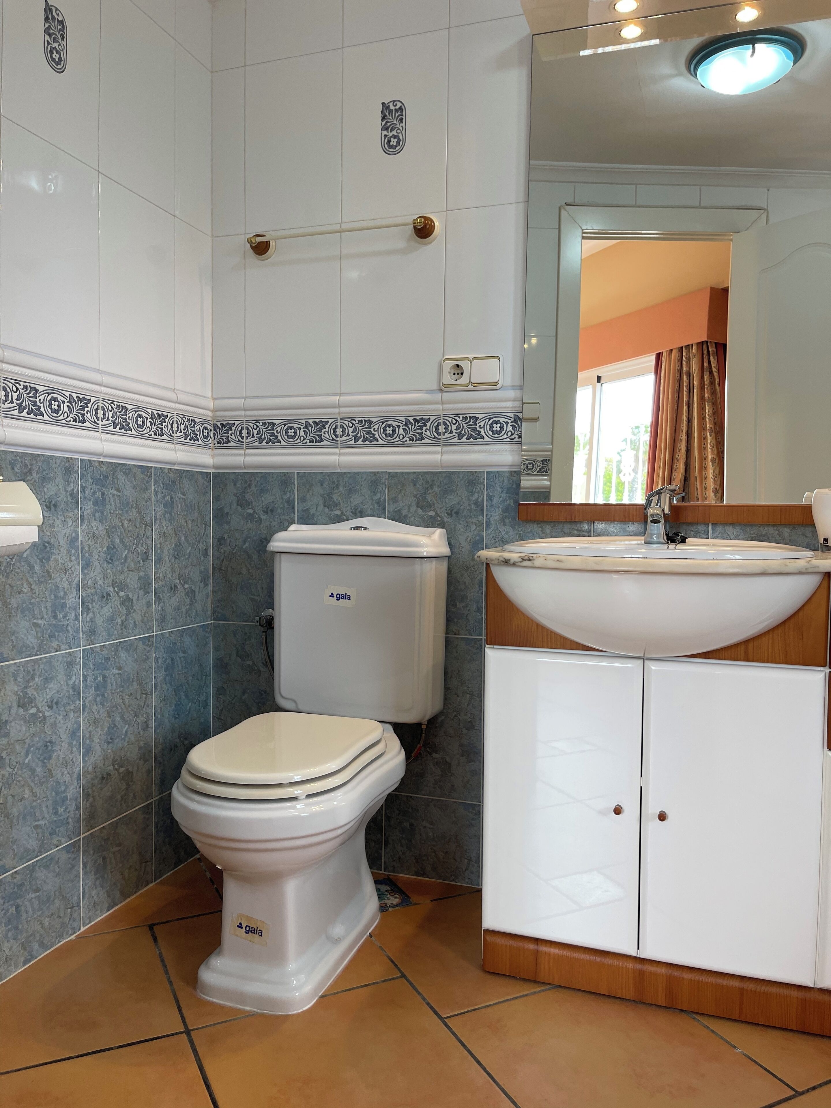 Un baño con inodoro, lavabo y espejo.