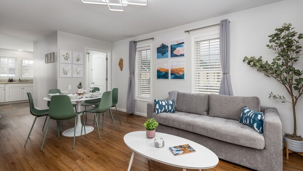 A modern living room with a grey sofa, green chairs, a white coffee table, and a dining area with a white table and chairs. - Starved Rock & Ottawa Retreat Amazing Getaway Home (Ottawa)