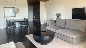 Een moderne woonkamer met een bank, een eettafel en een televisie.