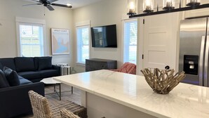 A modern kitchen with a marble countertop, a built-in refrigerator, and a ceiling fan. - BRAND NEW! Whalehead Beach Mediterranean Inspired Villa (Corolla)