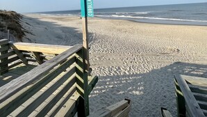 A beach with a wooden walkway leading to a sign reading "COROLLA VILLAGE". - BRAND NEW! Whalehead Beach Mediterranean Inspired Villa (Corolla)