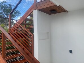 Stairs lead to an upper level with a handrail and wooden steps.