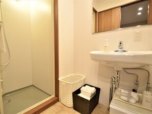 Ein Badezimmer mit Dusche, Waschbecken und Aufbewahrungskörben.