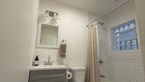 A bathroom with a toilet, sink, and bathtub. - Modern 3BR & 2BA Near McCormick & Downtown (Chicago)