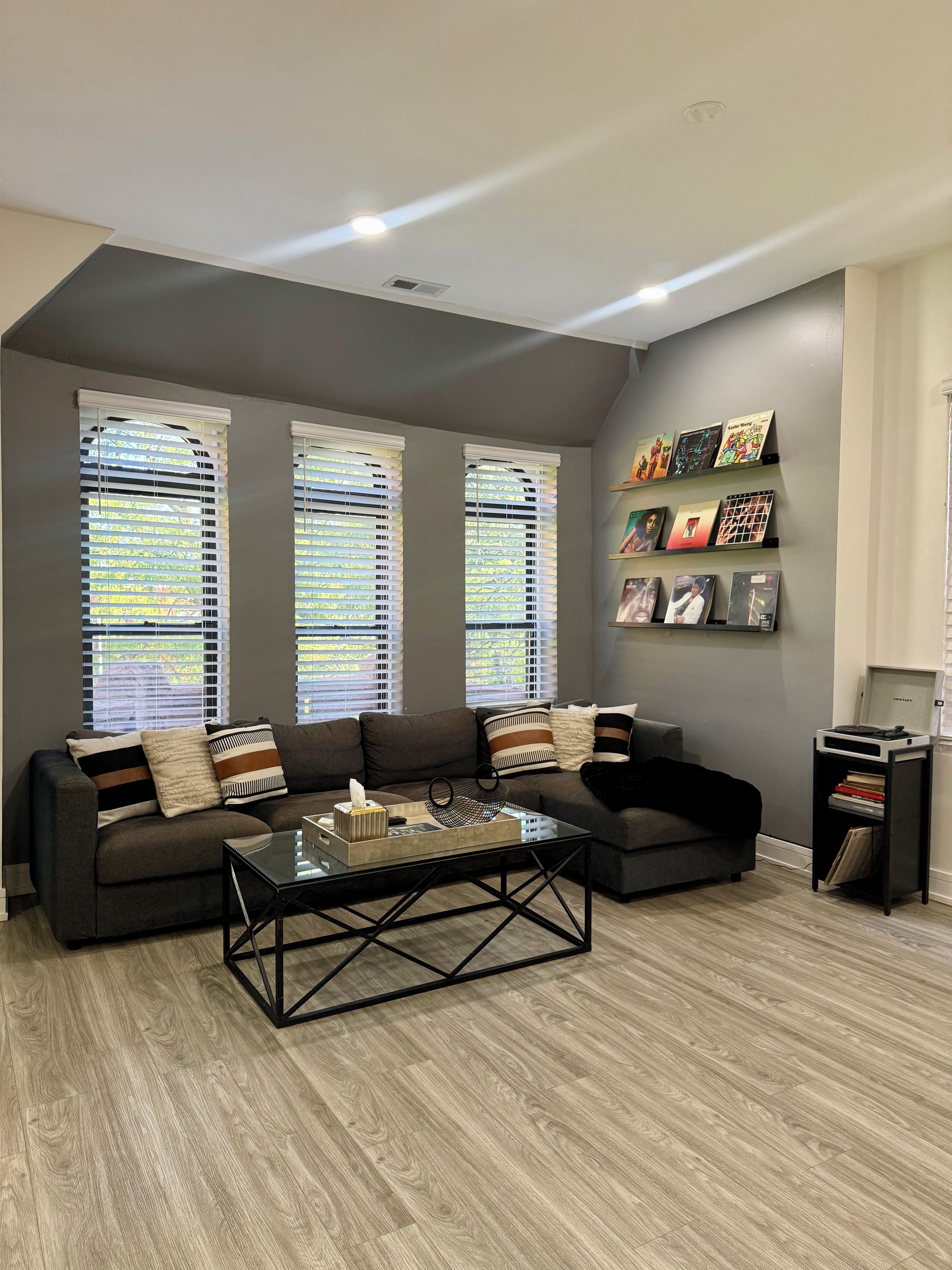 Una sala de estar moderna con un sofá modular, una mesa de centro de vidrio y una estantería.