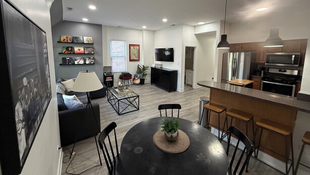A modern apartment with a dining area, kitchen, living room, and a TV. - Modern 3BR & 2BA Near McCormick & Downtown (Chicago)