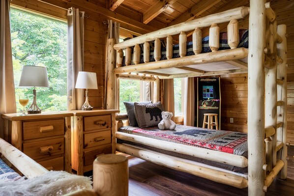 A wooden cabin room with a bunk bed, wooden desk, and a nightstand. - Stunning Fall Colors From Double Decks, 15 min to Gatlinburg, Firepit, HotTub (Sevierville)