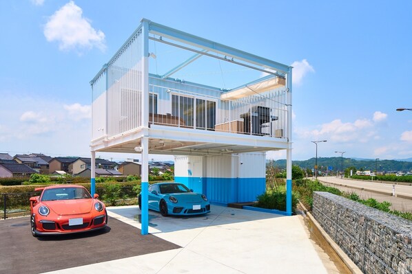 A covered parking structure with two cars parked inside. - ocean suite / Himi Toyama (Himi)