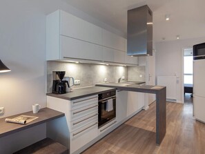 Eine moderne Küche mit Backofen, Kaffeemaschine und Mikrowelle.
