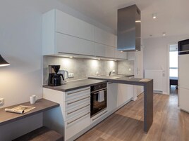 Una cocina moderna con horno empotrado, cafetera y microondas.