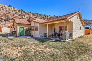 A single-story house with a covered porch, a garage, and a small yard. - Sedona 4BR Oasis with Stargazing Domes Hot Tub Sauna and Milky Way (Cornville)