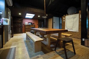 Enjoy dining and socializing at the long table, with a view of the outdoors through the large window.