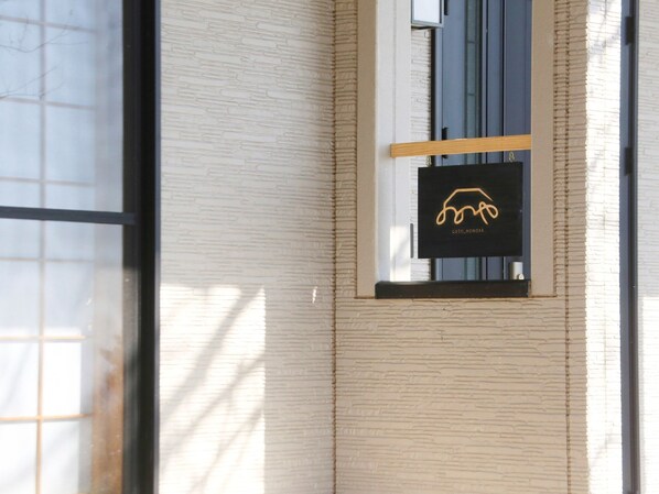 Eine Gebäudefassade mit einem Fenster, in dem ein Logo zu sehen ist.