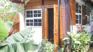A wooden house with a large window and a door. - Van Villa Holidays (Negril)