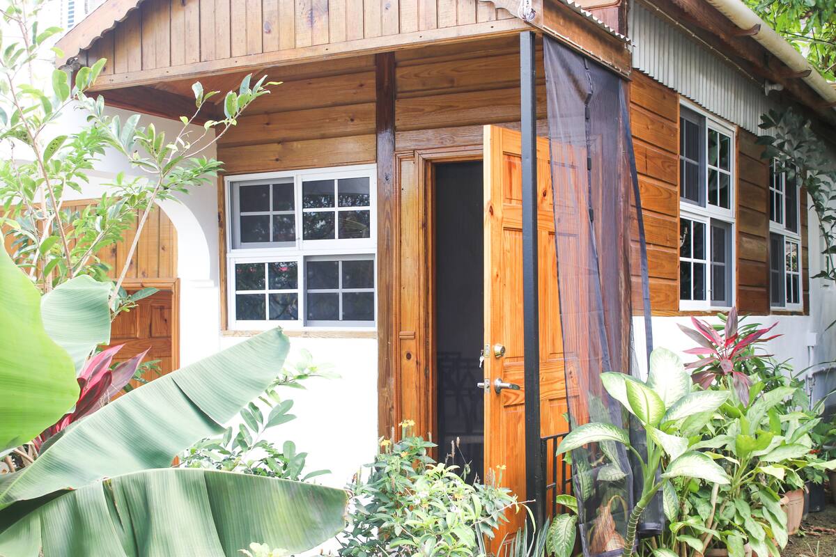 Uma casa de madeira com uma janela grande e uma porta.