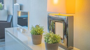 A reception desk with a flat-screen TV, a wall-mounted lamp, and two potted plants. - L'épuisette à Cassis by Winkyhouse (Cassis)