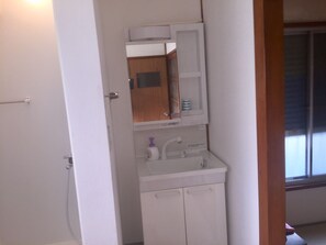 Bathroom with a sink, mirror, and window.