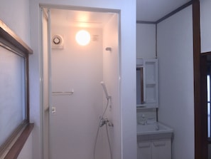Enjoy a refreshing shower in this bathroom with a handheld showerhead and wall-mounted faucet.