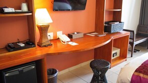 Reception area features a flat-screen TV, a desk with a curved top, and a small refrigerator.