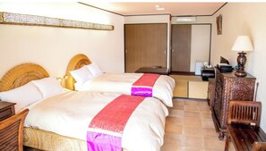 Habitación de hotel con dos camas, cabecera de madera, escritorio con lámpara, cómoda y espejo.