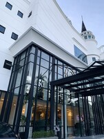 A modern building with large glass windows and a tower with a spire.
