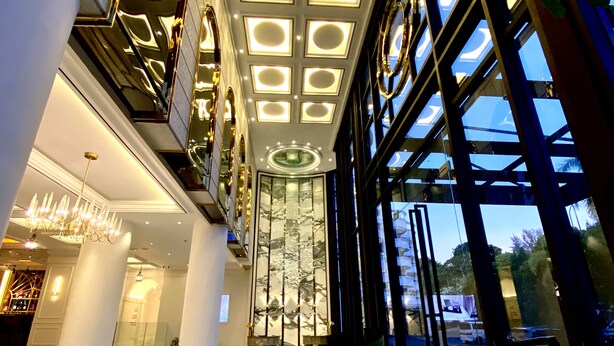 A modern hotel lobby with a high ceiling, large windows, and a central staircase. - Grand Eska Hotel & Suite  (Batam)