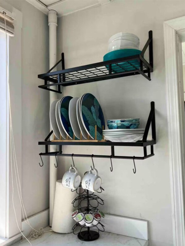 Un mueble esquinero con platos y tazas.
