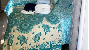 Un dormitorio con cama, ducha y una obra de arte colgada en la pared.