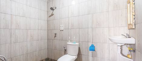 Un baño con inodoro, ducha y lavamanos.