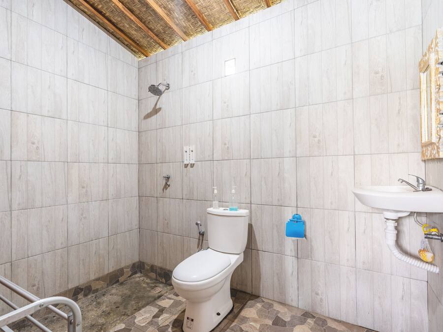 A bathroom with a toilet, shower, and sink.