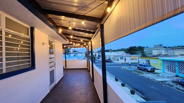 Un balcone con vista sulla strada, una ringhiera e luci decorative.