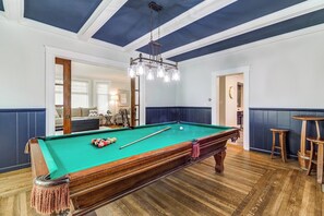 A pool table with a hanging light fixture, wooden flooring, and a blue and white color scheme. - Port Clinton 4 Bdrm Luxury-2 blocks from beach (Port Clinton)