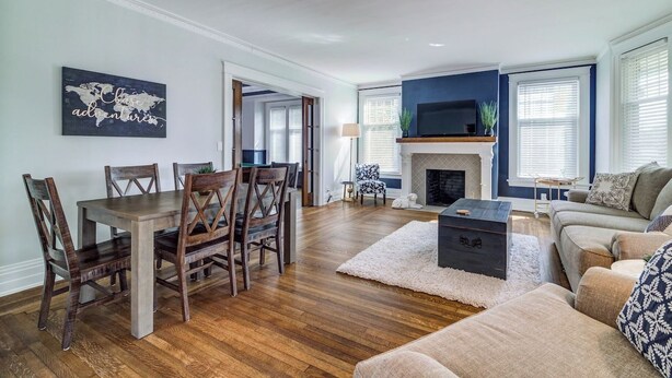 A living room with a wooden dining table, chairs, a sofa, a fireplace, and a television. - Port Clinton 4 Bdrm Luxury-2 blocks from beach (Port Clinton)