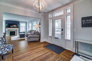 A spacious living room with hardwood flooring, a fireplace, a sofa, and a chandelier. - Port Clinton 4 Bdrm Luxury-2 blocks from beach (Port Clinton)