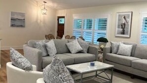 Un salon spacieux doté d’un ventilateur de plafond, d’un ensemble de canapés et d’une table basse.